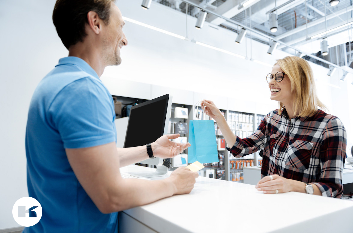 Extremely happy young lady making purchases at electronics store